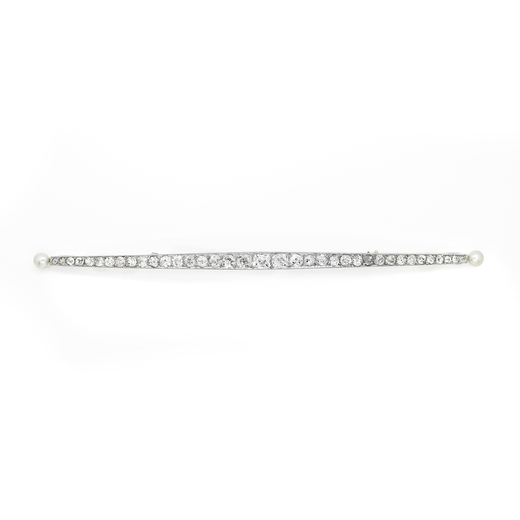 SPILLA IN PLATINO, PERLE E DIAMANTI, CIRCA 1900 semi bombata decorata allestremità con piccole perl