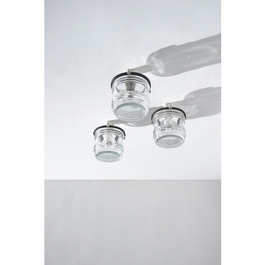 TITO AGNOLI (ATTRIB. A) Tre lampade a plafone. Alluminio pressofuso, vetro stampato, gomma. Produzio