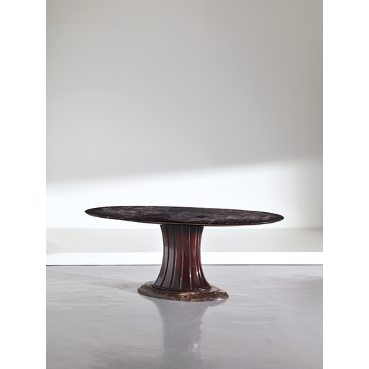 VITTORIO DASSI    Grande tavolo ovale. Legno di noce tinto, marmo giallo reale, marmo rosso Lepanto.